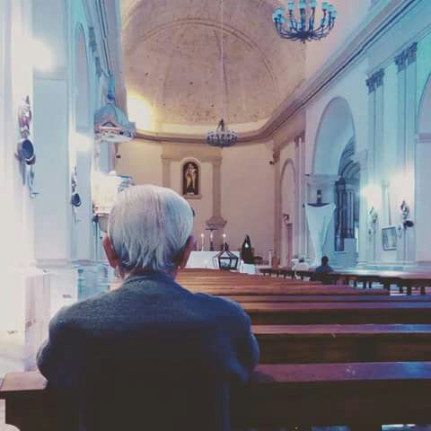Padre Domínguez en oración dentro de una iglesia